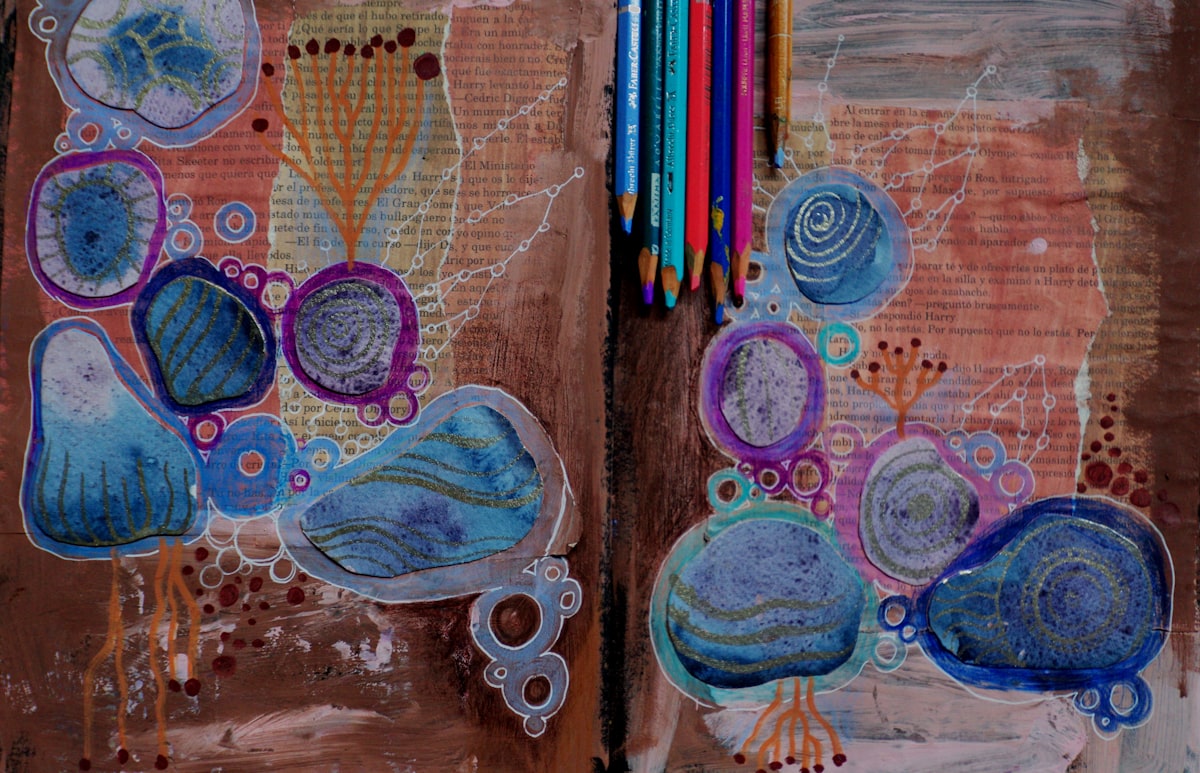 Abstract blue shapes and colored pencils on brown paper, a simple art journal setup