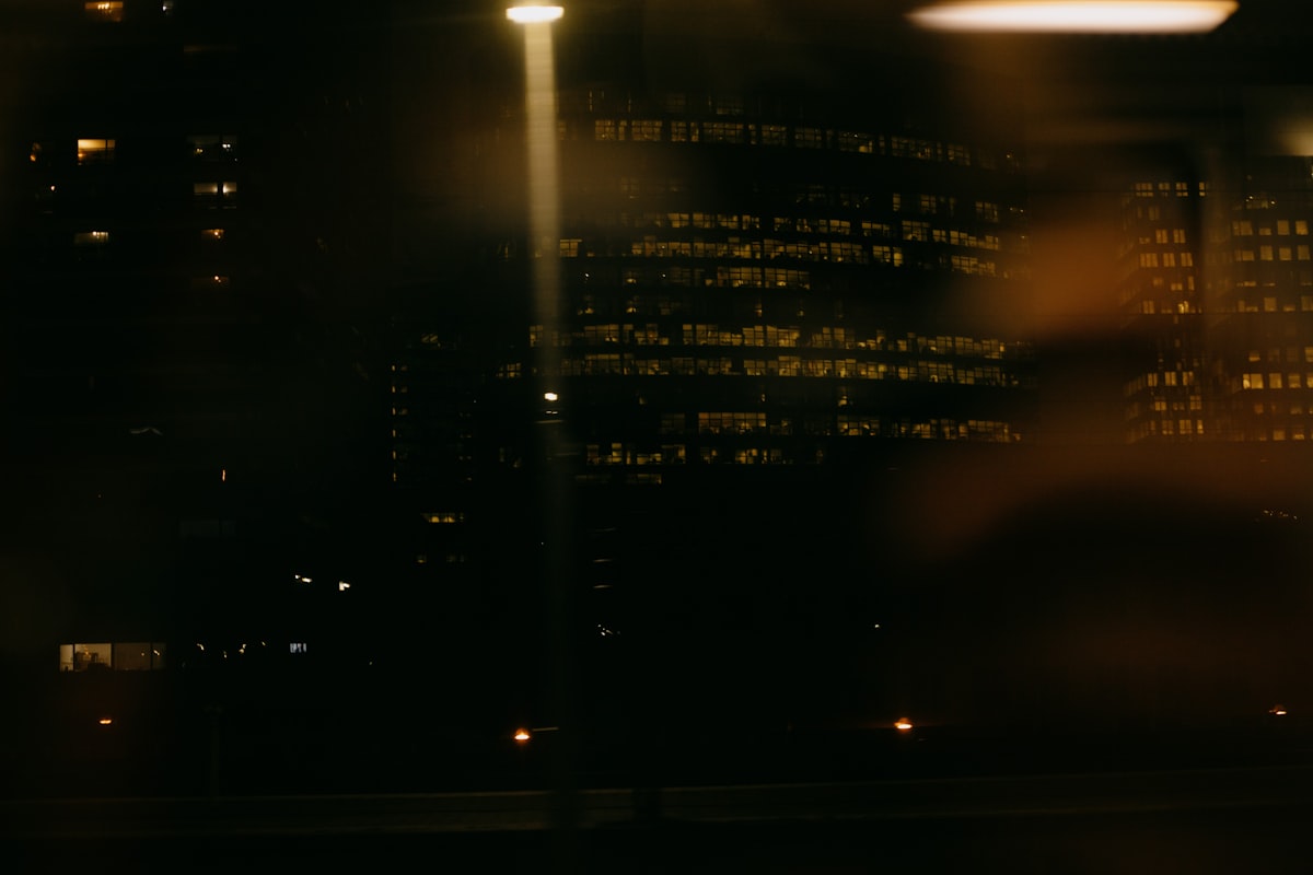 An open notebook on a wooden desk by soft lamplight in the evening