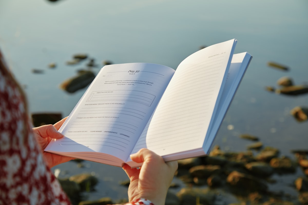 A person peacefully holding a book in a calm natural setting