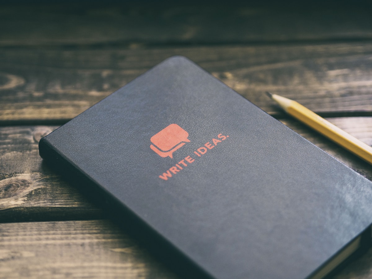 A 'Write Ideas' book resting on a brown wooden board, suggesting idea generation on the page