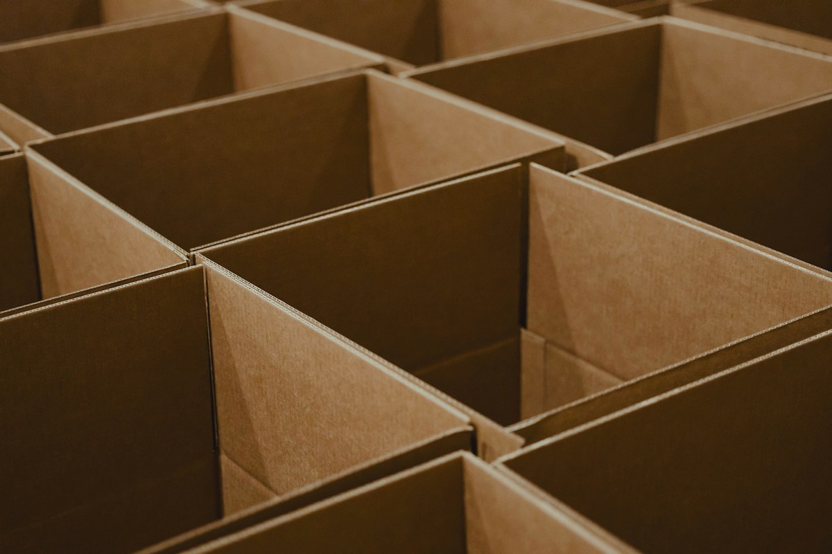 Open brown cardboard moving boxes stacked together during a life change