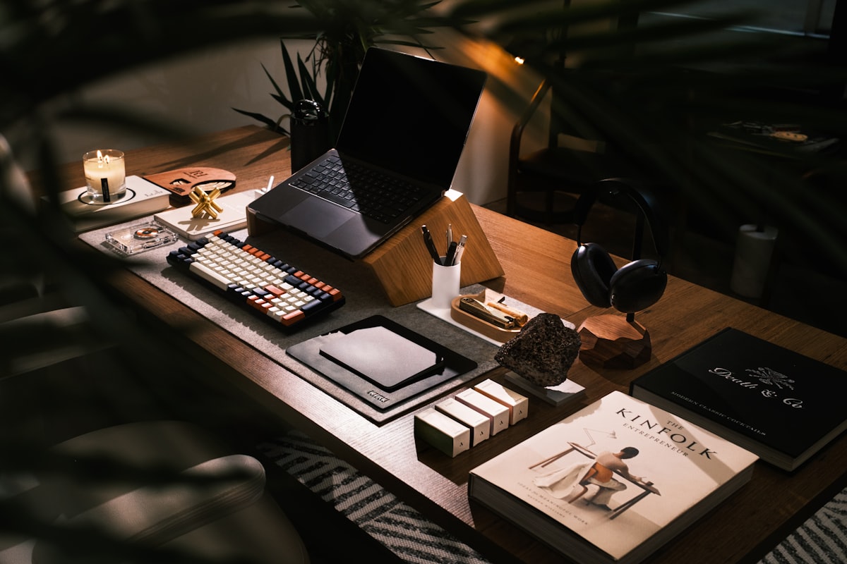 A modern desk setup with laptop and books, representing journaling supplies