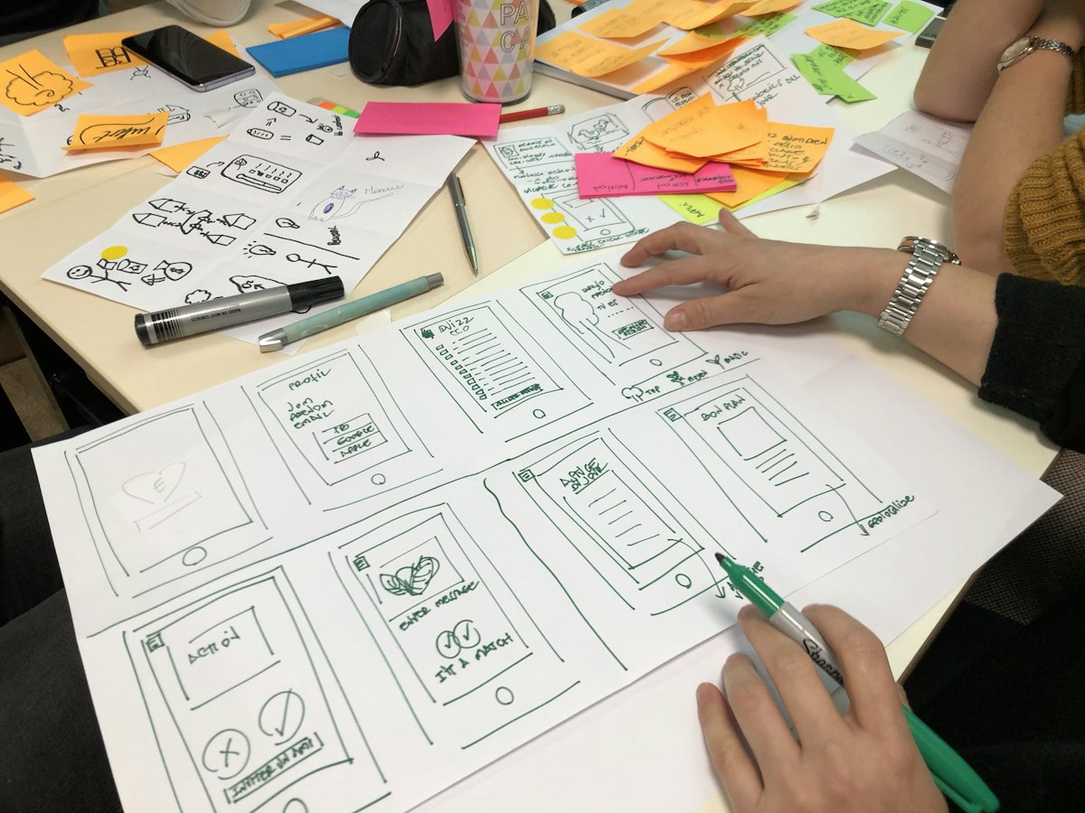 A person sketching ideas on a sheet of paper at a desk