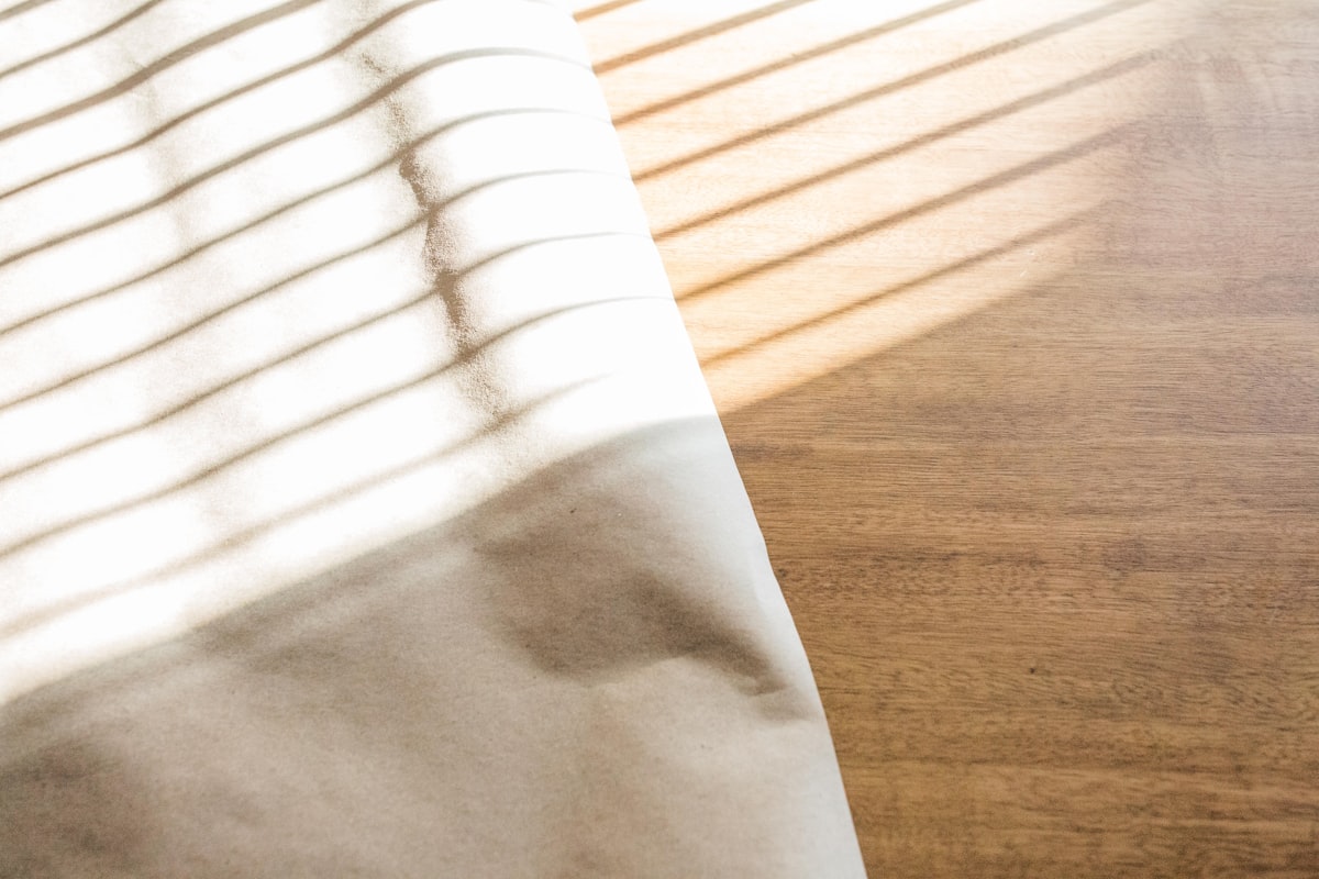 A blank sheet on a wooden table, suggesting an ordinary day ready for a fresh entry