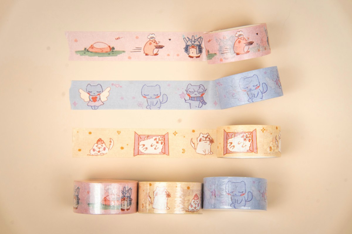 Four rolls of patterned washi tape with playful designs, ready for decorating a journal